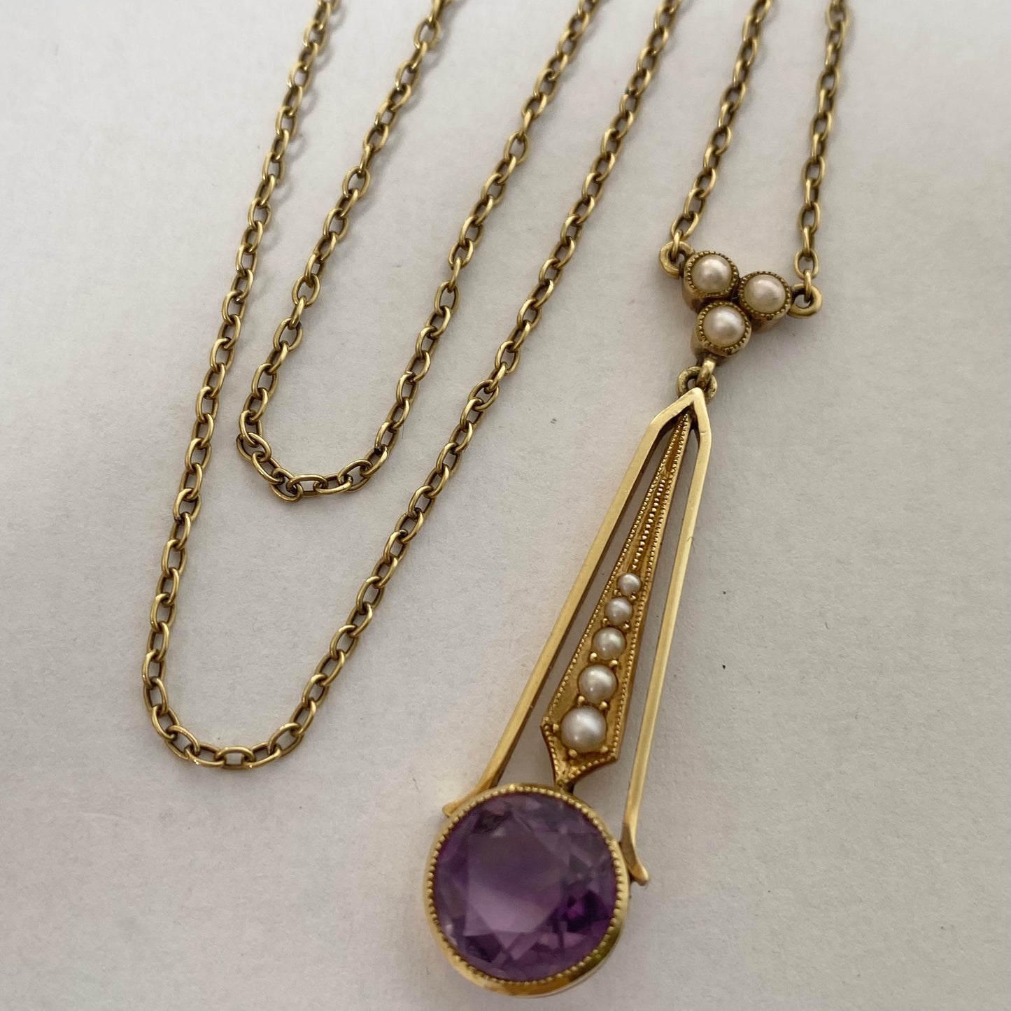 An Edwaridan 15ct gold amethyst and split pearl pendant, with integral chain.