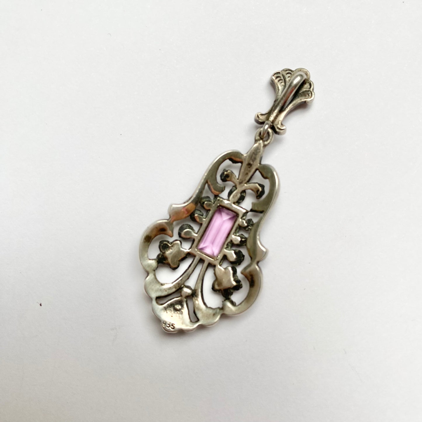 An early 20th century colourless and purple paste foliate pendant.