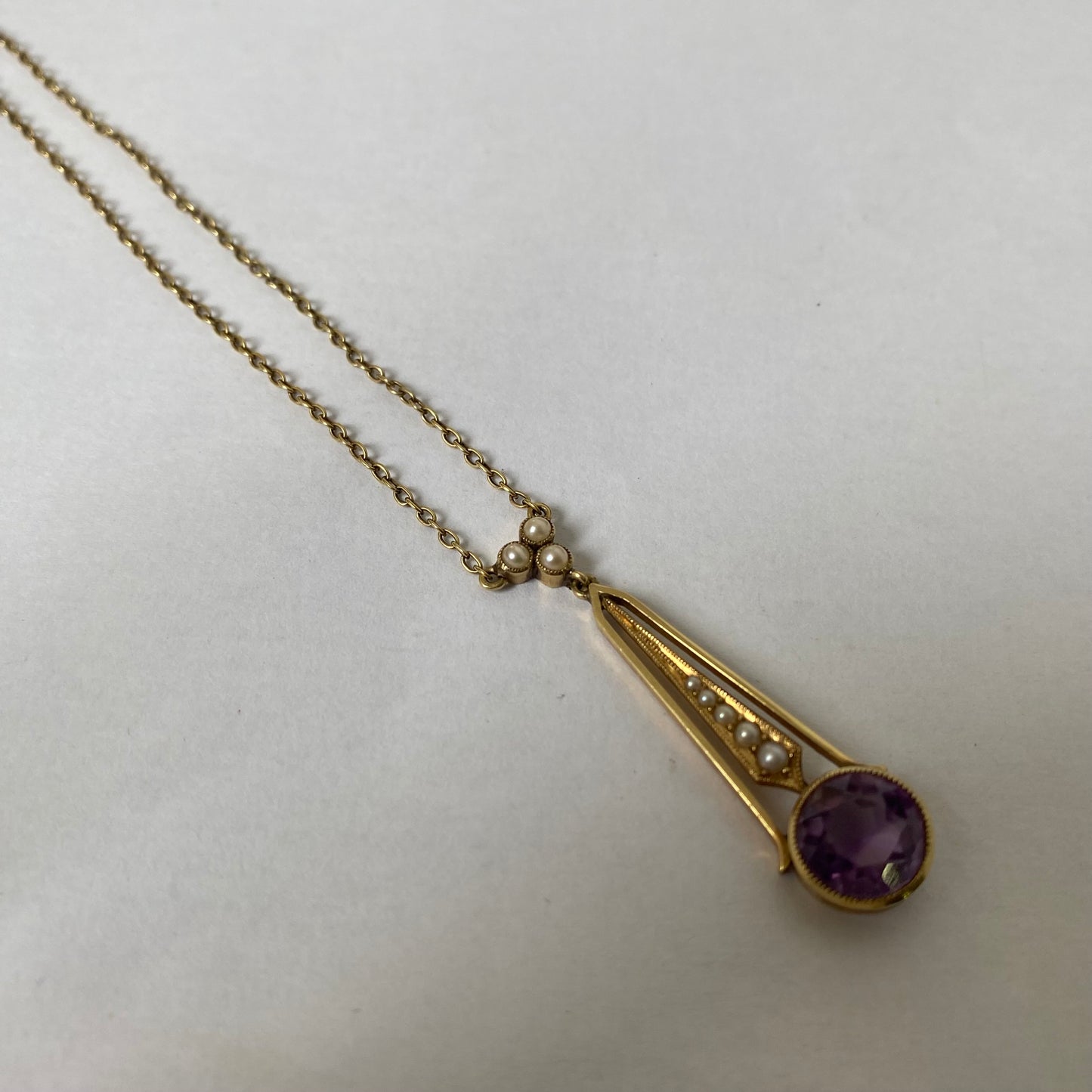 An Edwaridan 15ct gold amethyst and split pearl pendant, with integral chain.