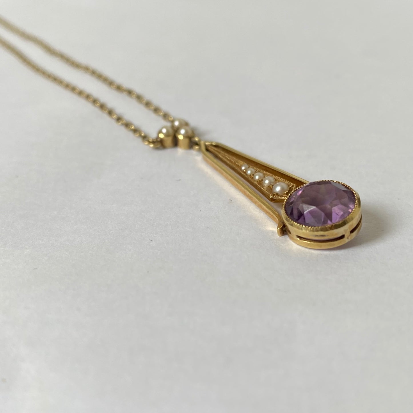 An Edwaridan 15ct gold amethyst and split pearl pendant, with integral chain.