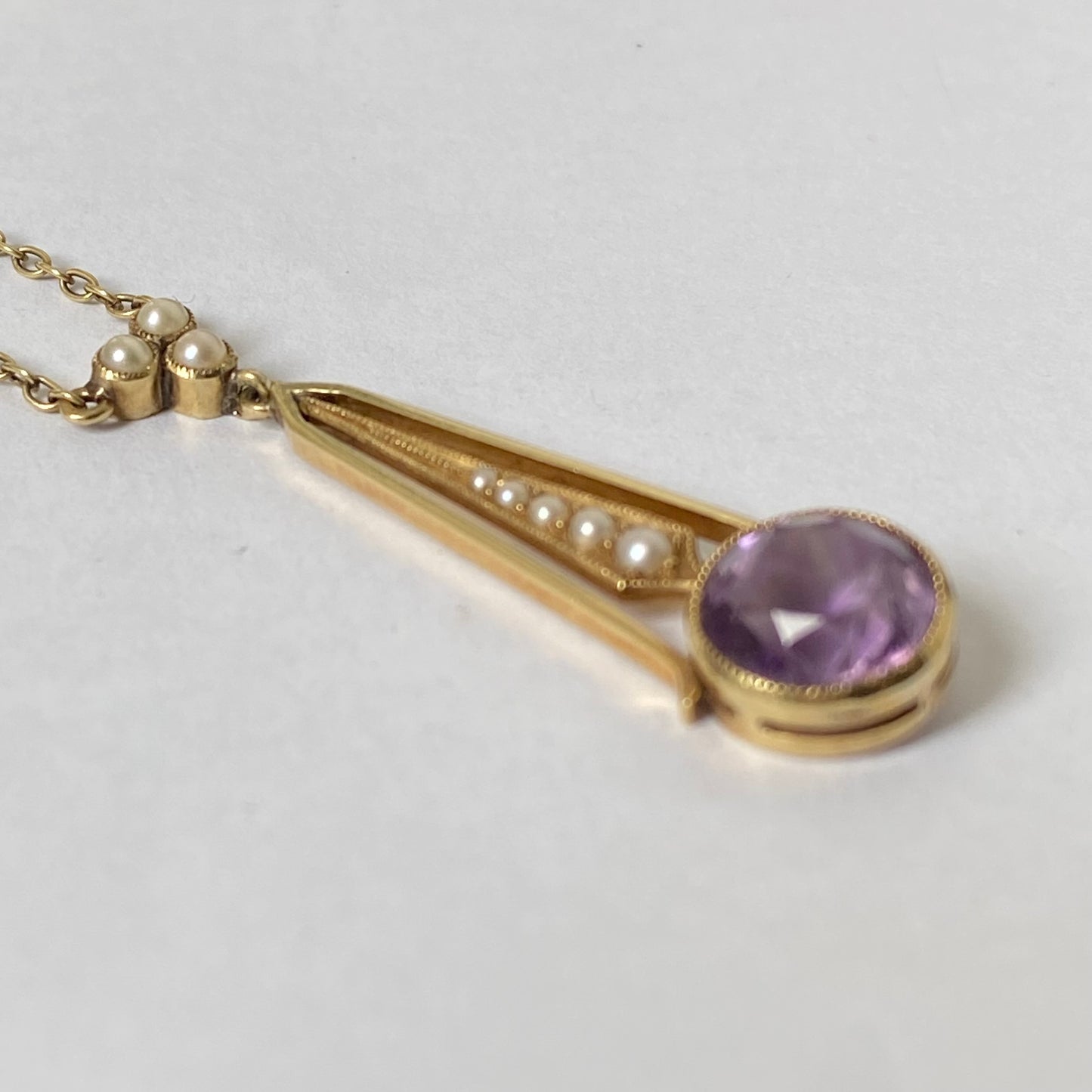 An Edwaridan 15ct gold amethyst and split pearl pendant, with integral chain.