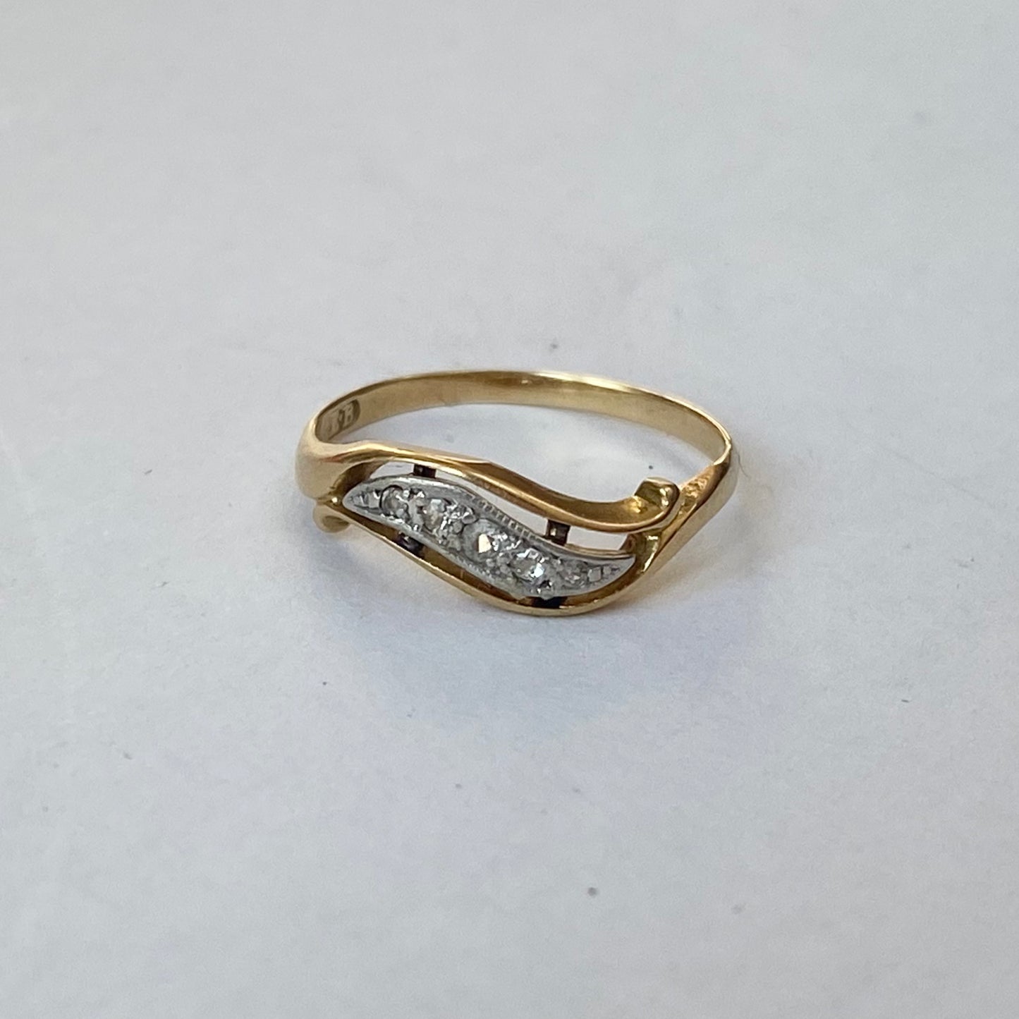 A mid 20th century gold old cut diamond undulating pinky ring.