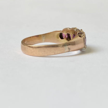 An early 20th century gold garnet five-stone ring, with seed pearl highlights.