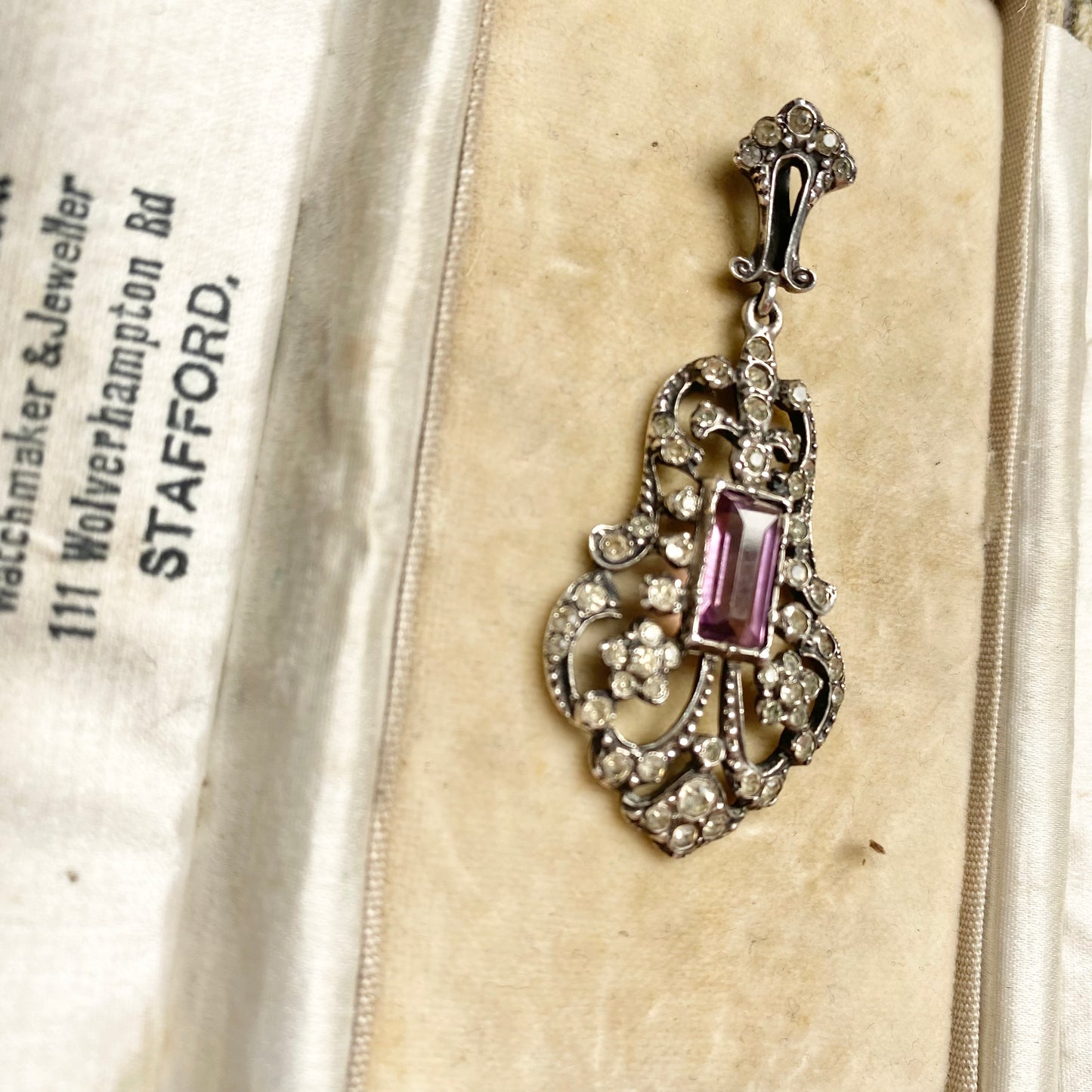 An early 20th century colourless and purple paste foliate pendant.