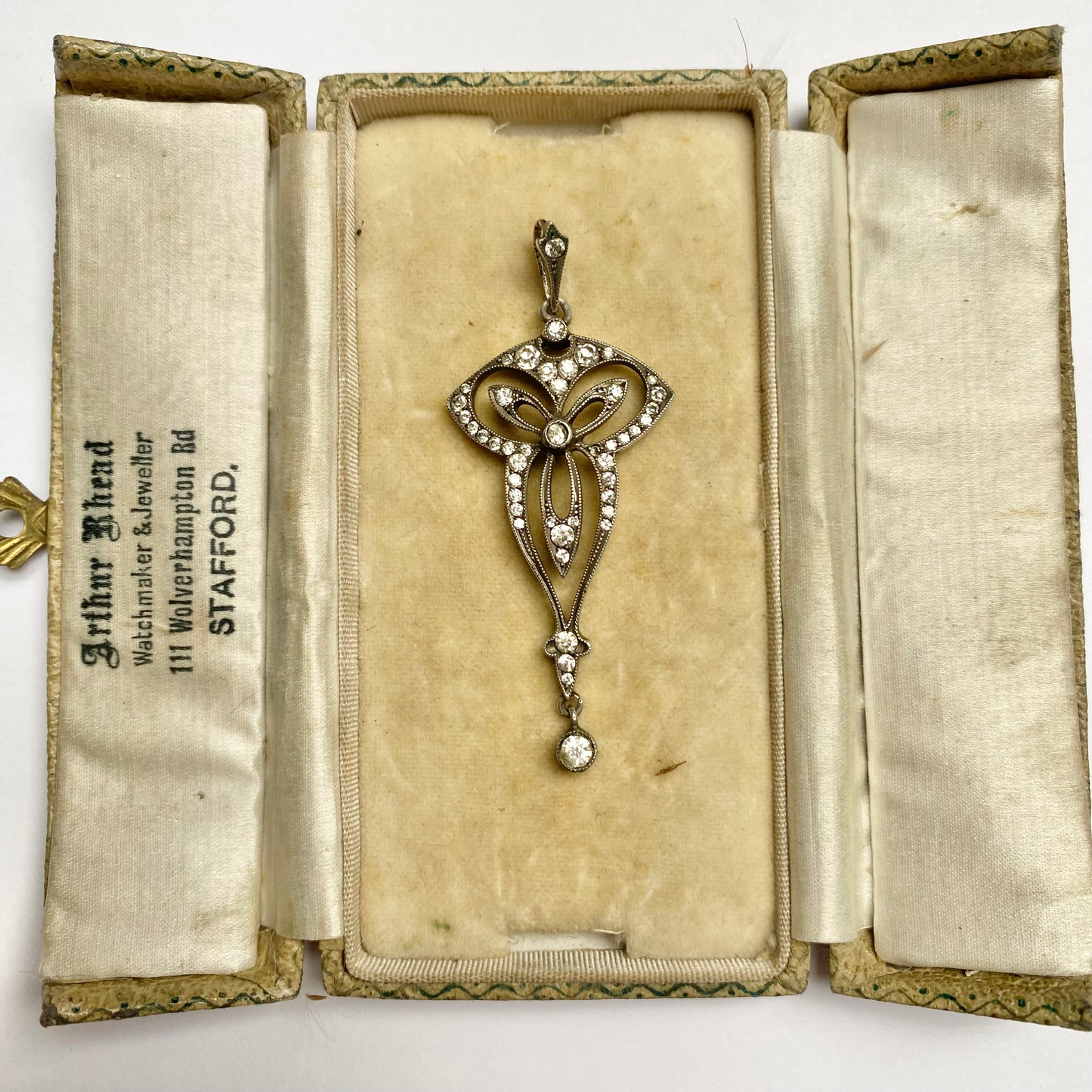 An Edwardian silver colourless paste foliate pendant.