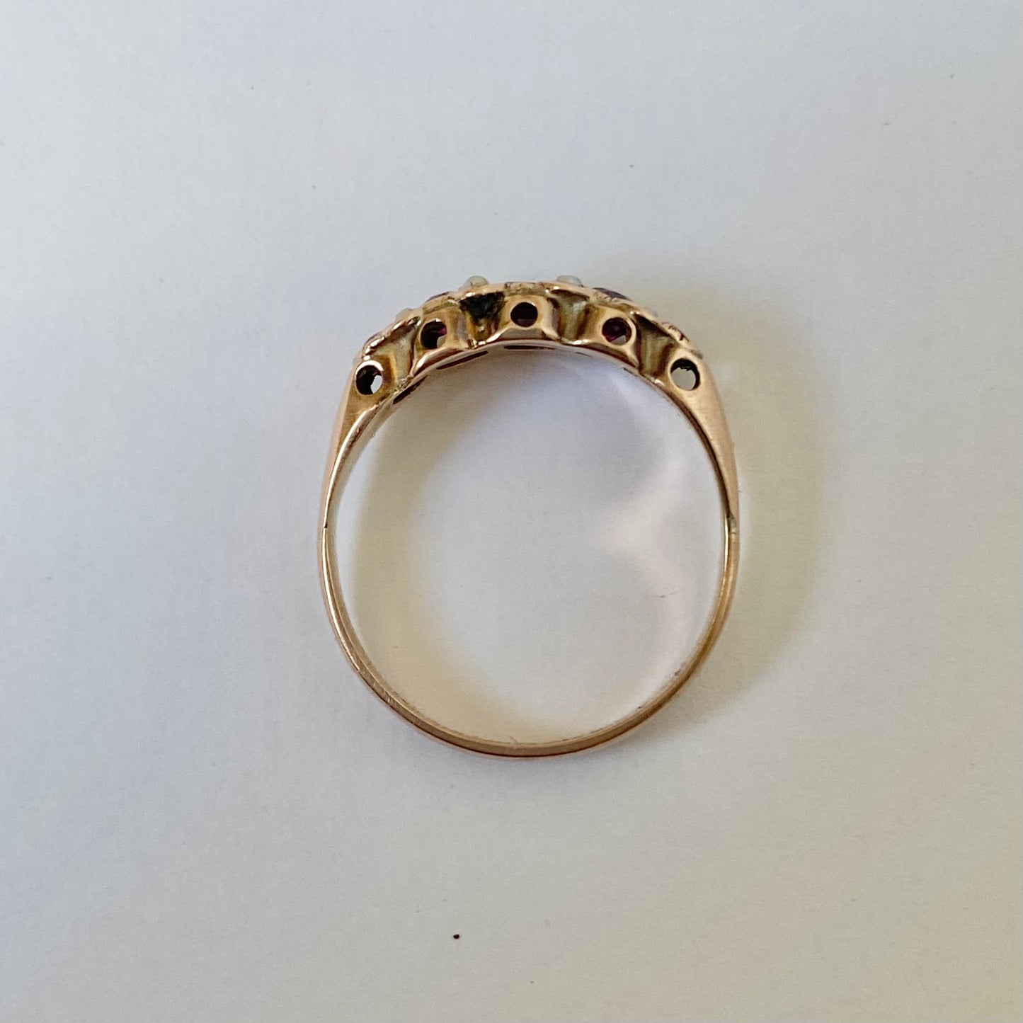 An early 20th century gold garnet five-stone ring, with seed pearl highlights.