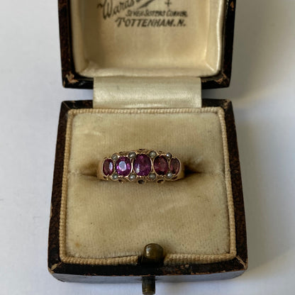 An early 20th century gold garnet five-stone ring, with seed pearl highlights.