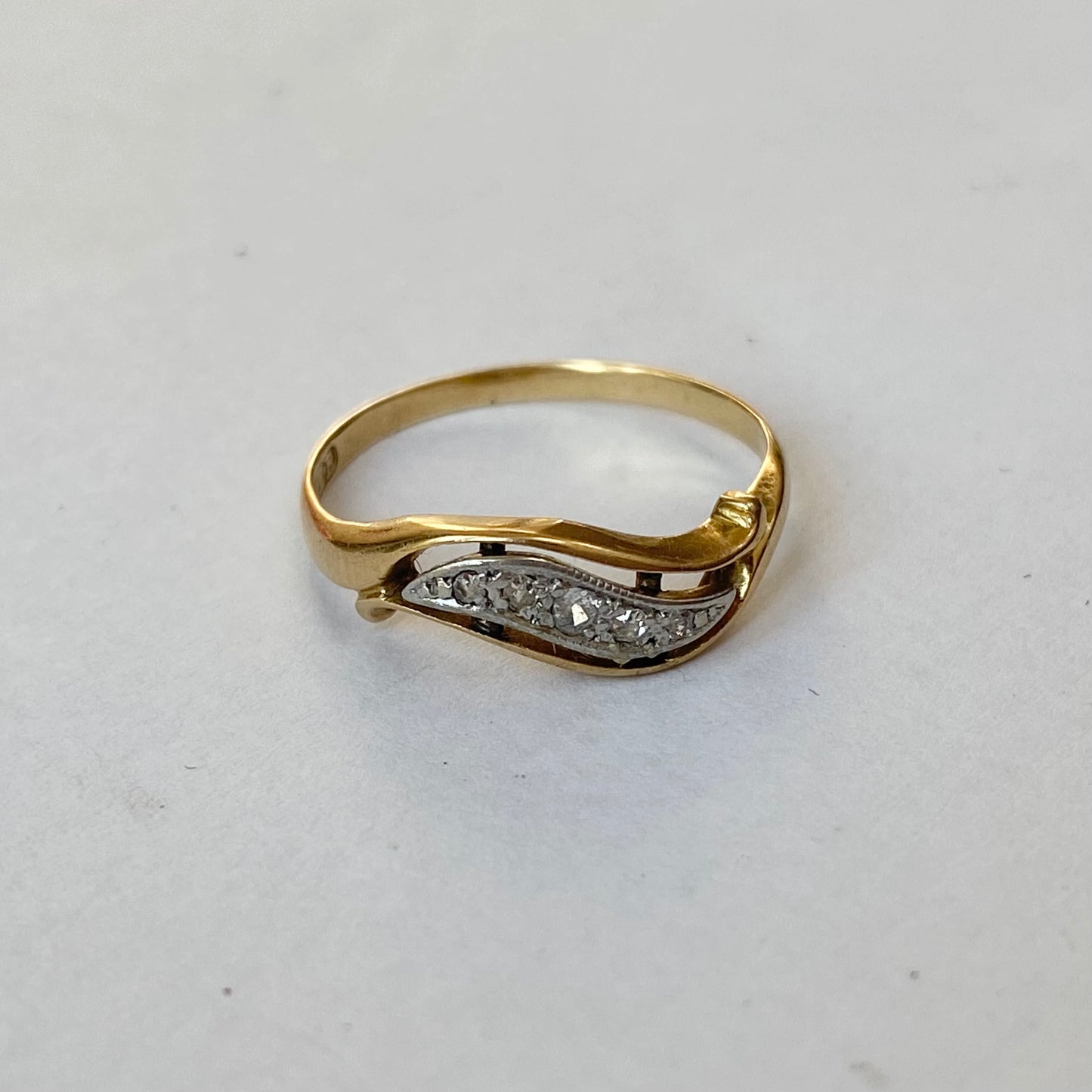 A mid 20th century gold old cut diamond undulating pinky ring.