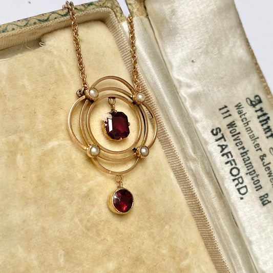 Early 20th garnet and split pearl scalloped pendant, with integral chain,