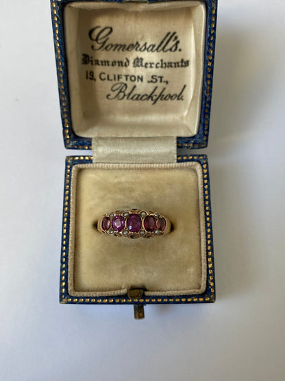 An early 20th century gold garnet five-stone ring, with seed pearl highlights.