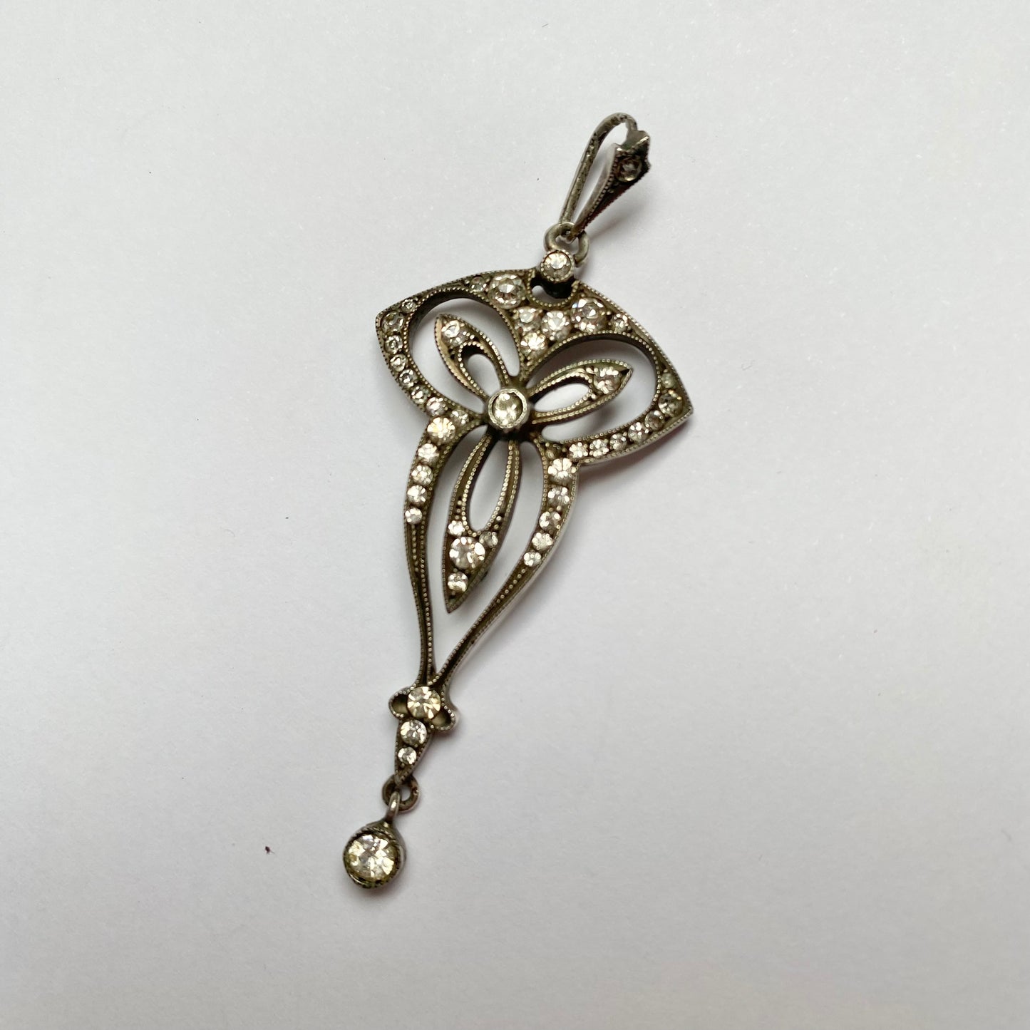 An Edwardian silver colourless paste foliate pendant.