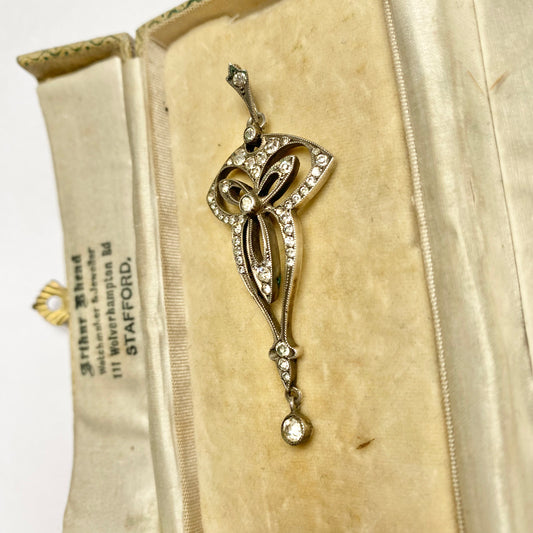 An Edwardian silver colourless paste foliate pendant.